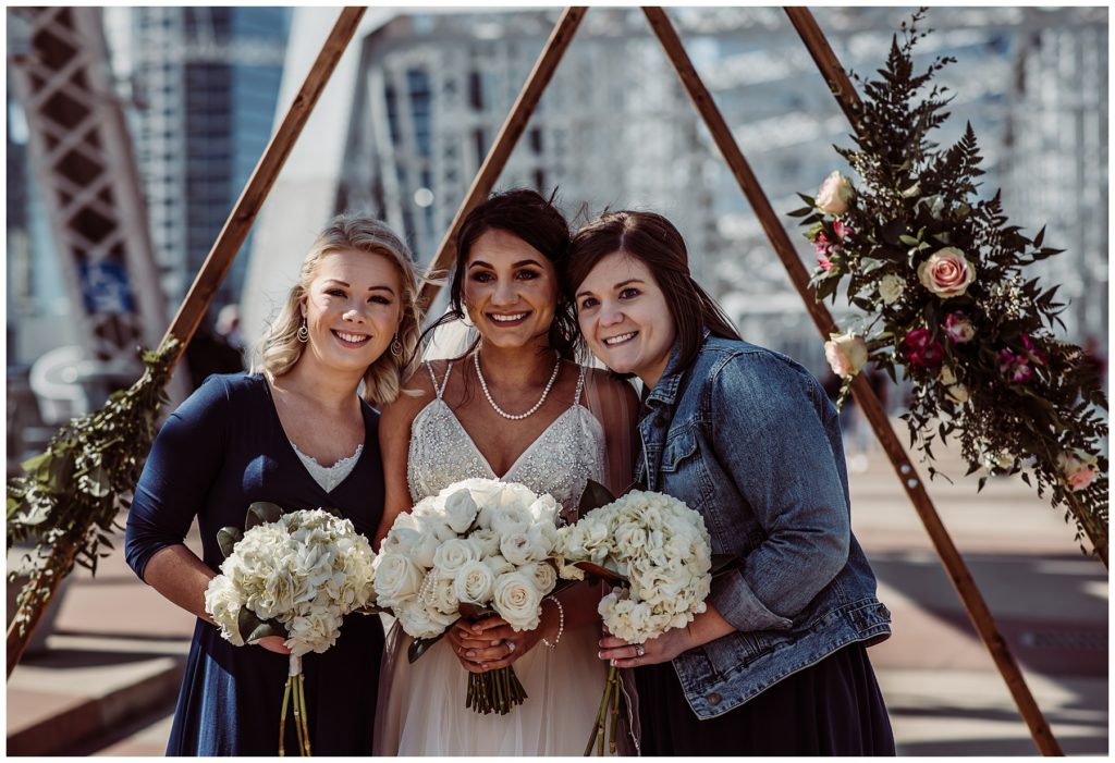 Bride posing with bridesmaids during spring wedding in the city