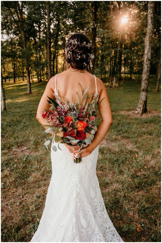 Bride holding bouquet behind back during August Summer wedding