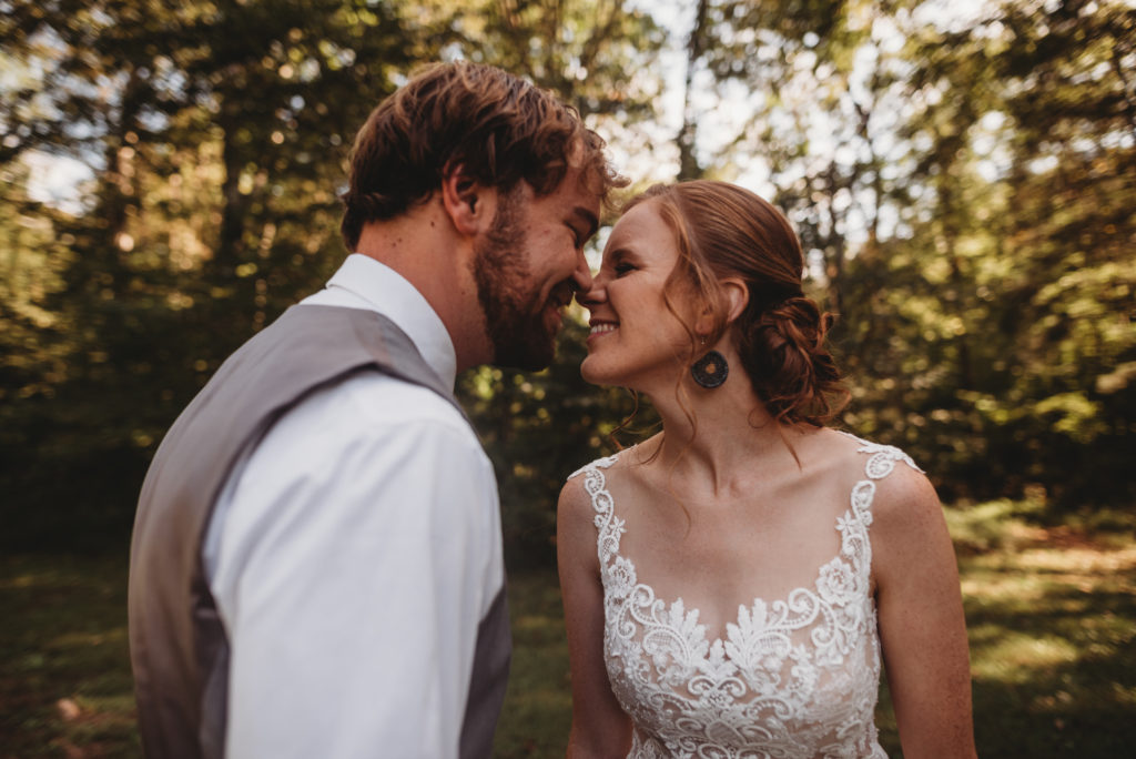 bride and groom smiling at one another on elopement day touching noses