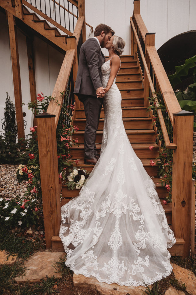bride and groom standing on wooden staircase at cascata wedding venue