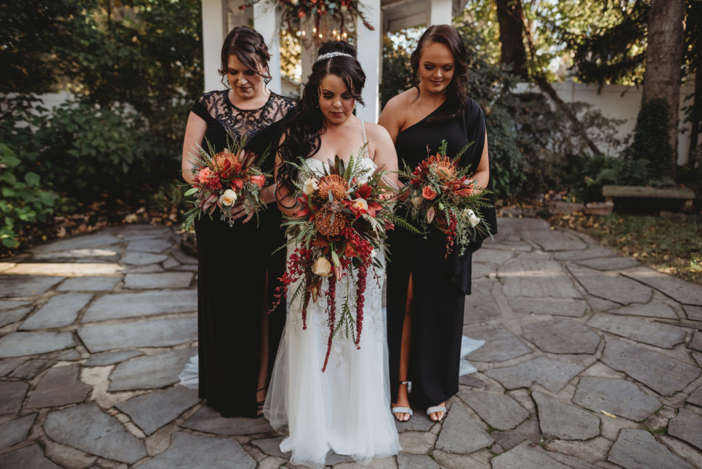 bride and bridesmaids holding bouquets and looking down during bridals session in tennessee