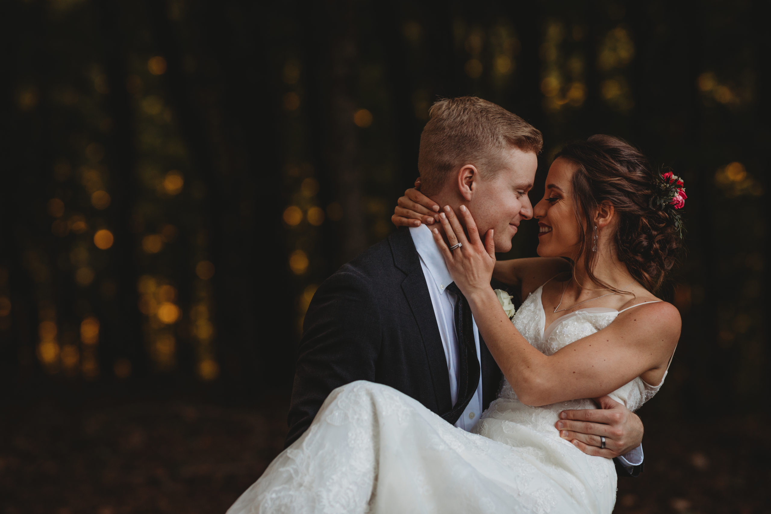 groom carrying bride through knoxville forest and celebrating recent marriage