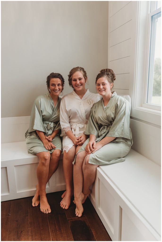 bride smiling with bridesmaids before wedding