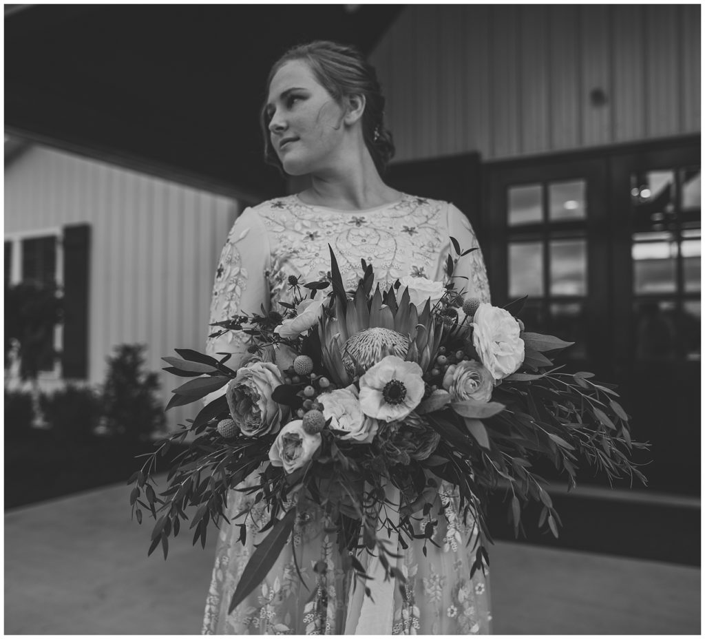 bride holding bridal bouquet in front of venue