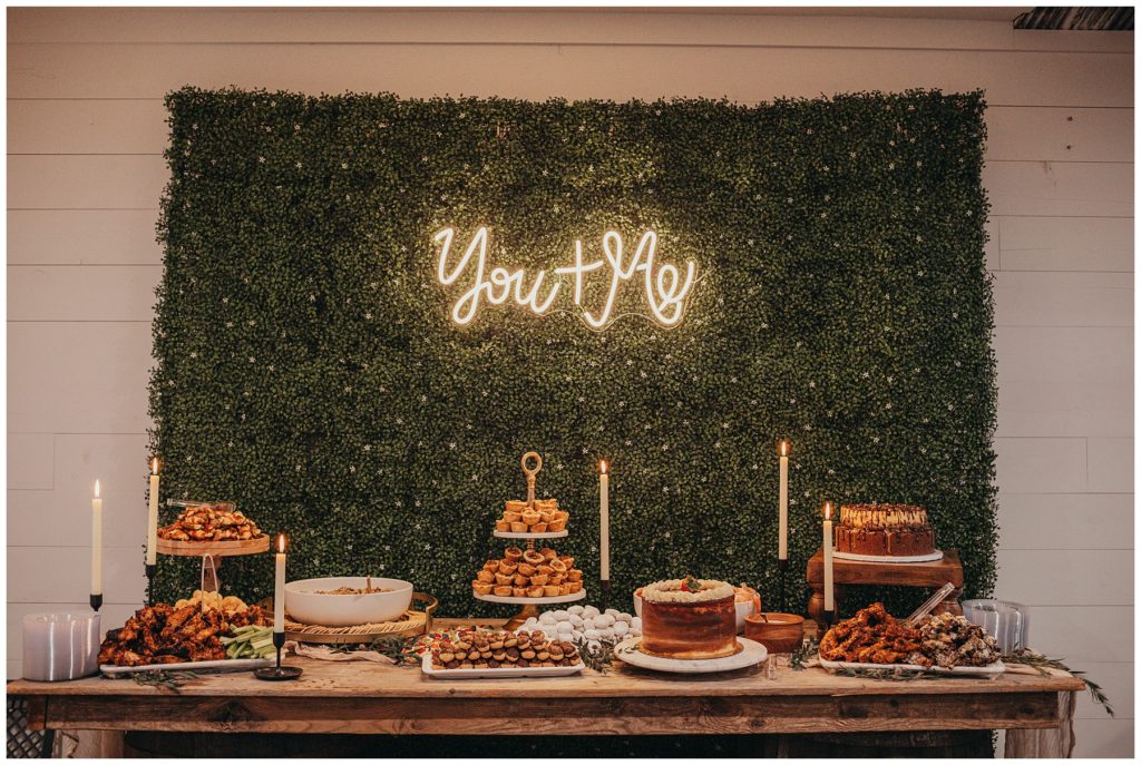 dessert table with neon sign behind it