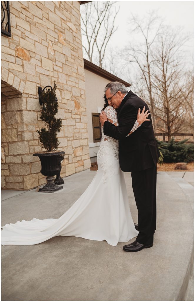 bride hugging father after seeing each other for first time on wedding day
