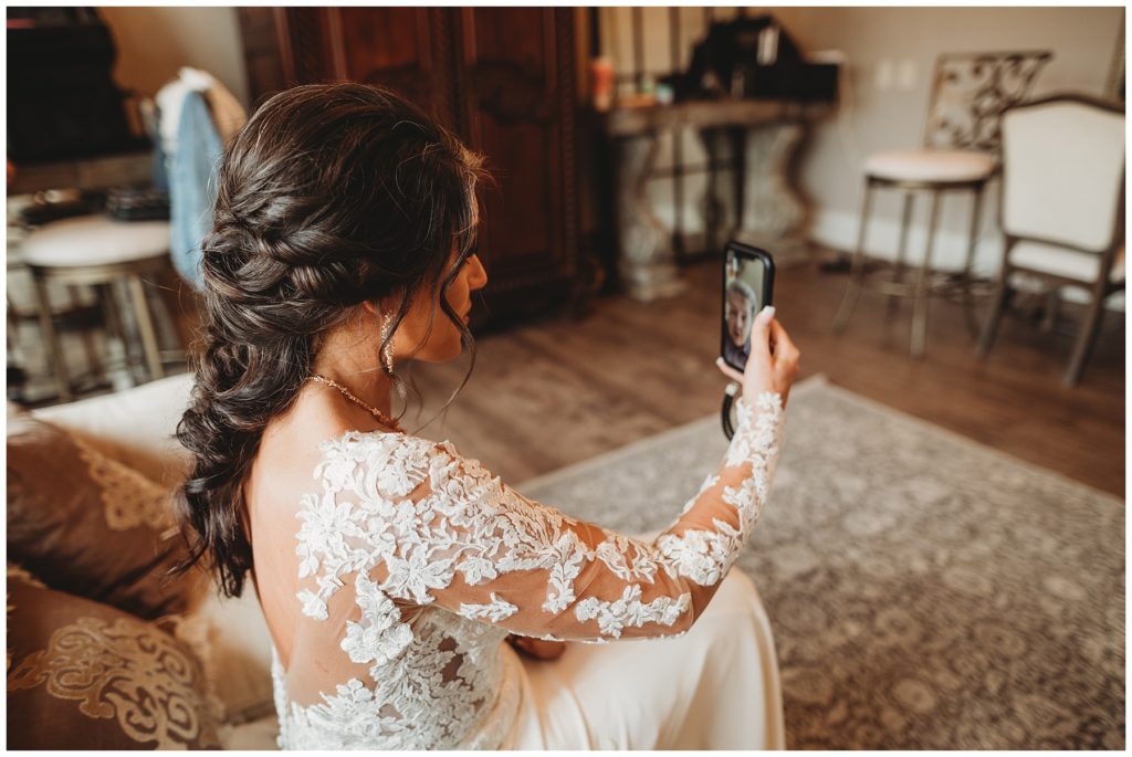 woman holding phone and facetiming family on wedding day
