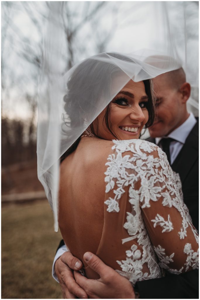 bride and groom under veil during bridals