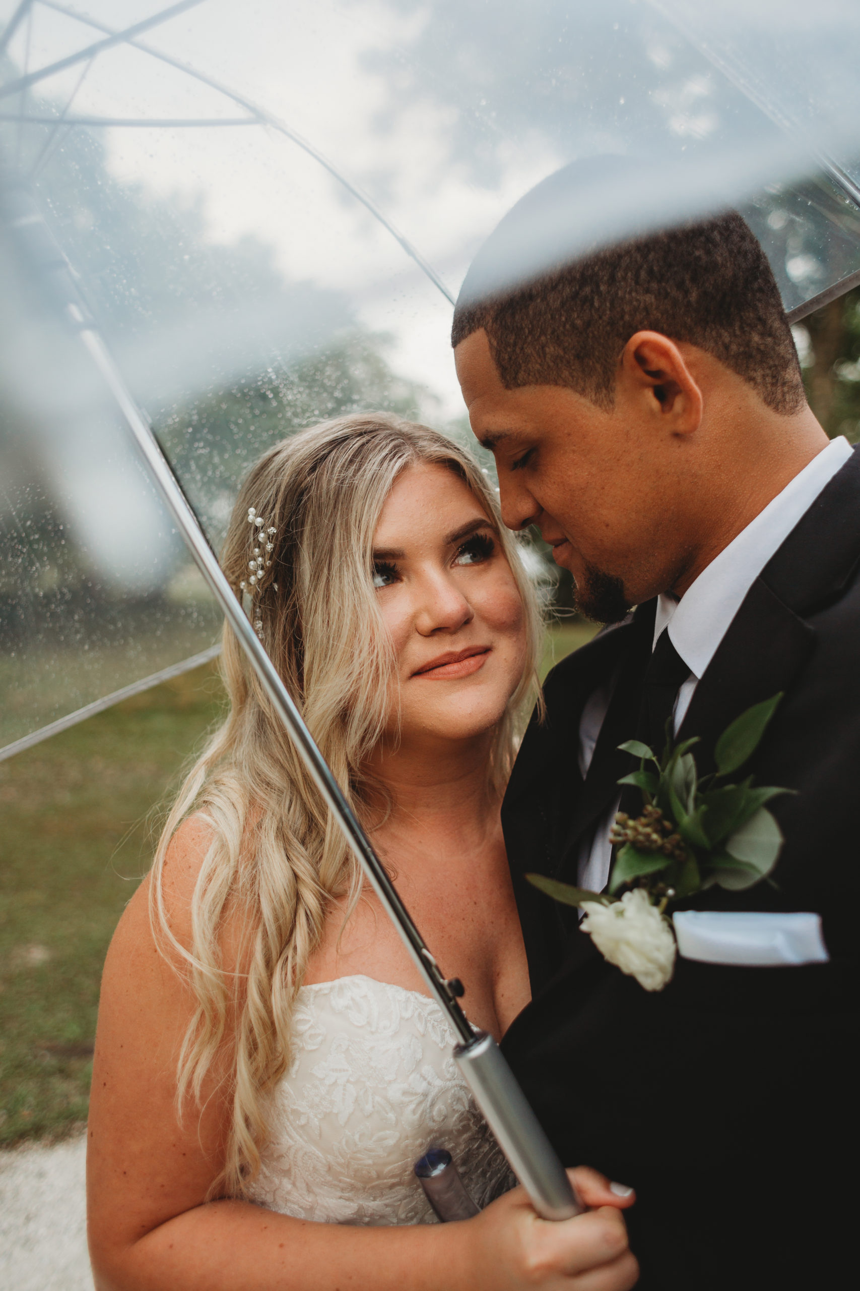 Vero Beach Wedding, bride and groom holding a clear umbrella to get out of the rain on their Florida wedding day