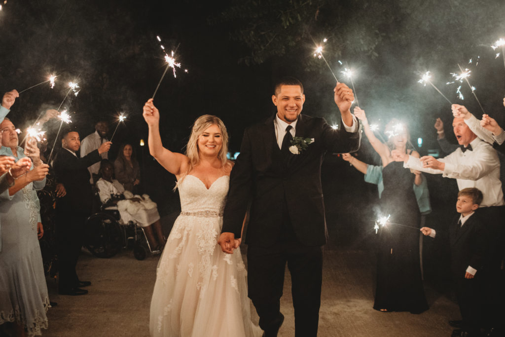 bride and groom walking through sparklers for their Vero Beach wedding day fairwell