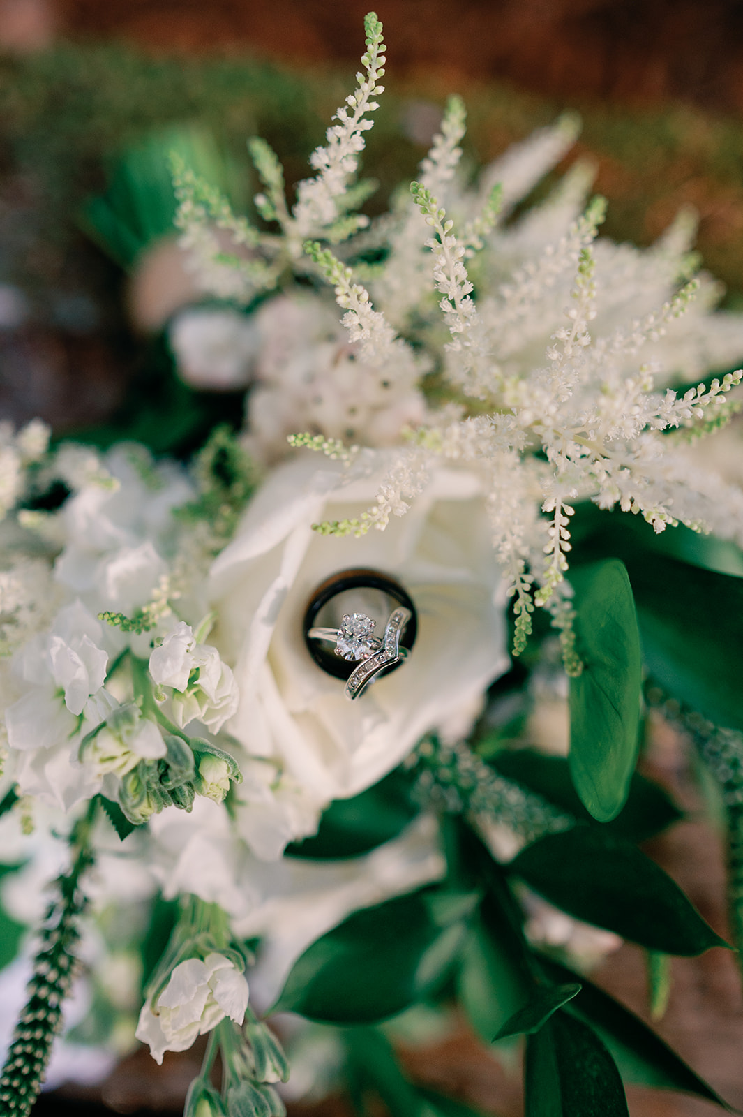 Details of wedding rings sitting in a white rose bouquet at a Joshua Tree Wedding