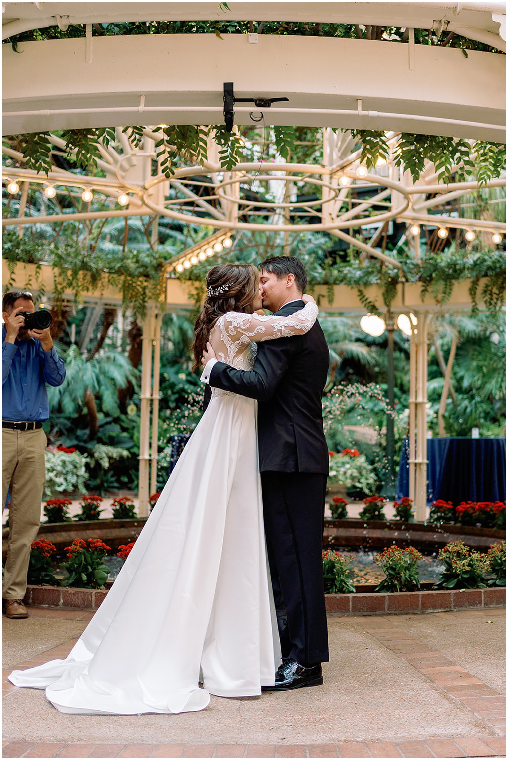 Newlyweds kiss while standing in a garden