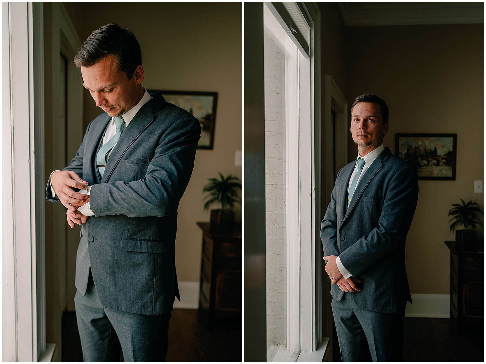 A groom puts on his cufflinks while standing in a window in a grey suit