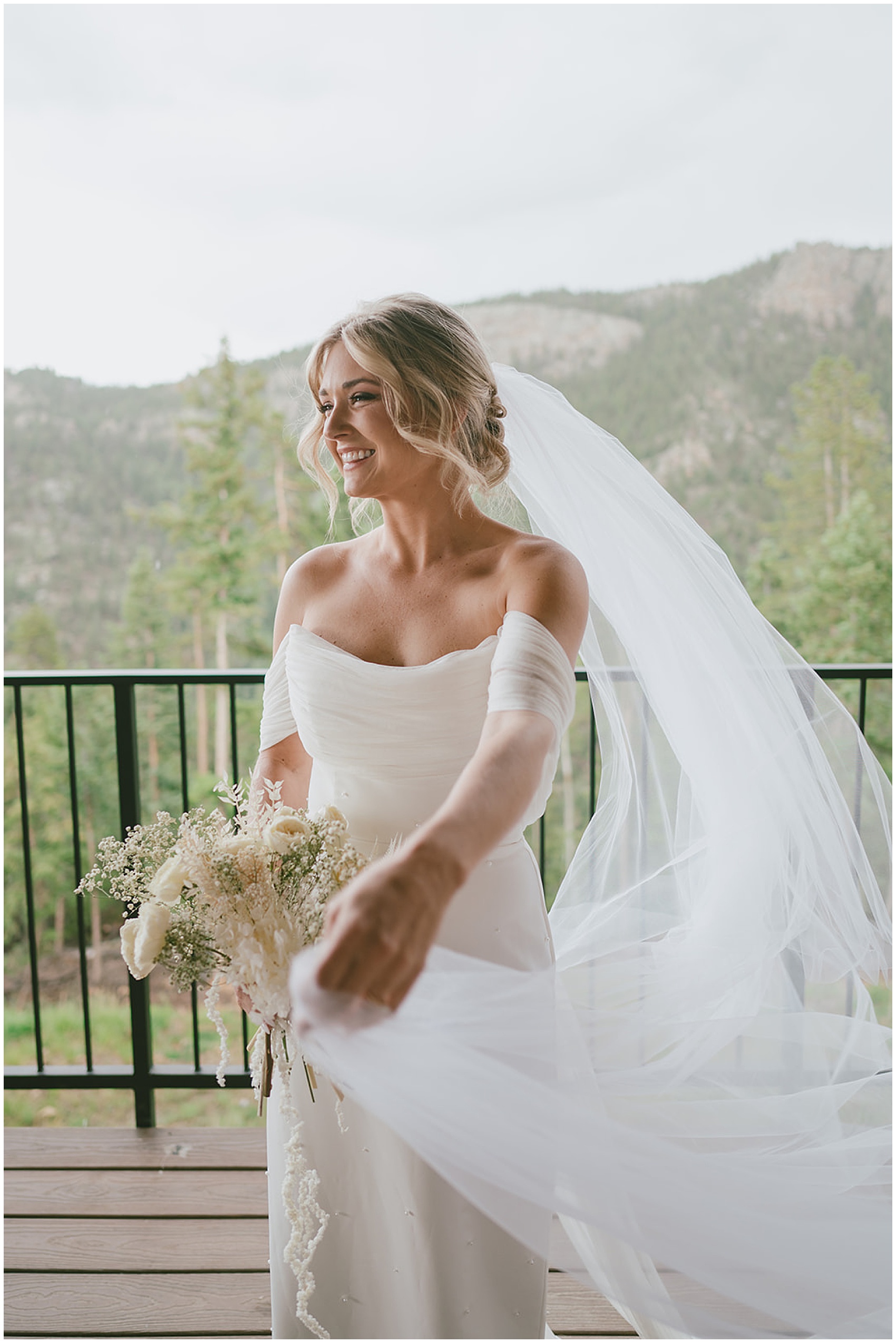 A bride walks on a deck holding her white rose bouquet