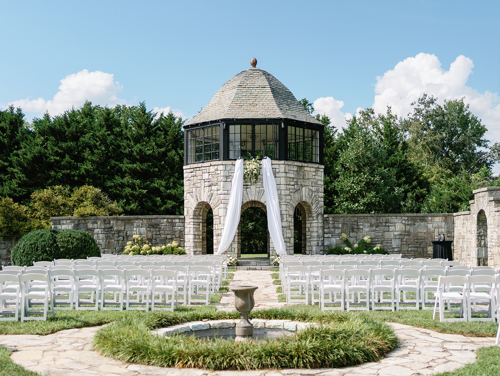 Details of a wedding ceremony set up in a garden with white chairs at a Kincaid House Wedding